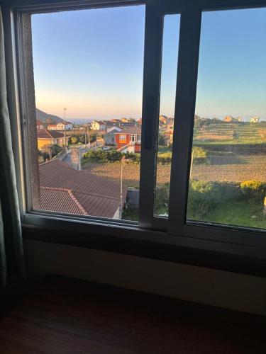 an open window with a view of a city at Hotel Restaurante O Esqueiro in Malpica