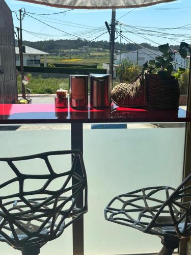 a table with two candles and a chair on it at Hotel Restaurante O Esqueiro in Malpica