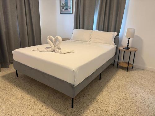 a bedroom with a bed with white sheets and pillows at Wynwood Bungalows By Renzzi in Miami