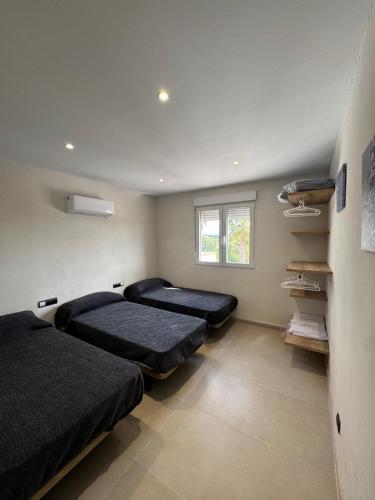 a bedroom with two beds and a window at Eucaliptus in Camarles