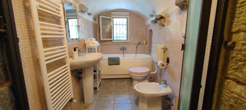 a bathroom with two sinks and a toilet and a tub at La Casa delle Pietre Parlanti - Casa in pietra ai piedi del parco delle 5 Terre in Biassa