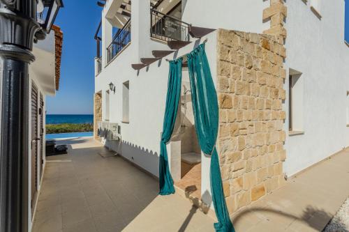 a building with blue umbrellas on the side at Kallisti Beach & Spa Villa - A Luxury Seaside Retreat in Lachi