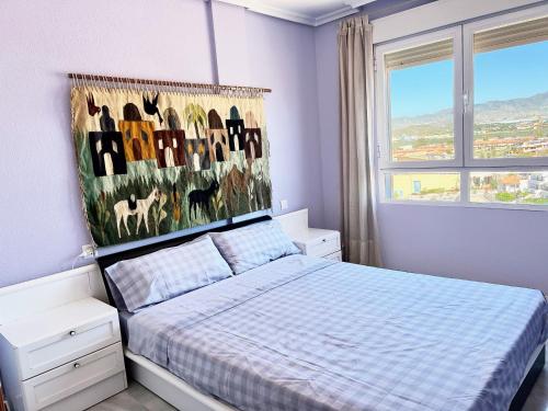 ein Schlafzimmer mit einem Bett und einem Gemälde an der Wand in der Unterkunft Hornillo Vistas al Mar in Águilas