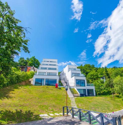 a building on a grassy hill next to a building at Royal Terrace Konjic in Železnička Stanica Ostrožac