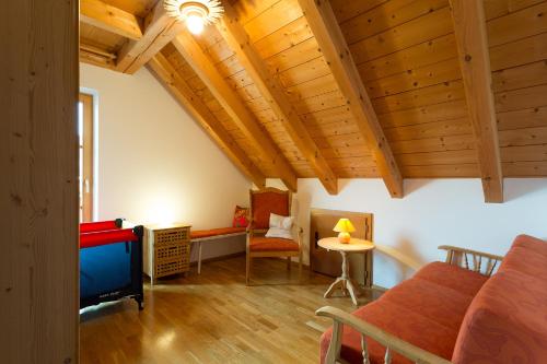 a living room with wooden ceilings and a tv at Zum Kirchenbauer in Oberammergau