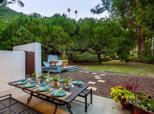 a patio with a wooden table with plates on it at Sea Change by Paradise Retreats in Santa Barbara