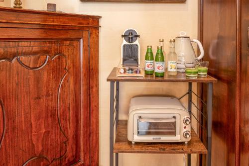 a small table with a microwave and bottles on it at Apartment Manzoni Bardolino Center in Bardolino