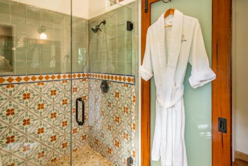 a robe hanging on a shower door in a bathroom at Sea Ranch by Paradise Retreats in Montecito