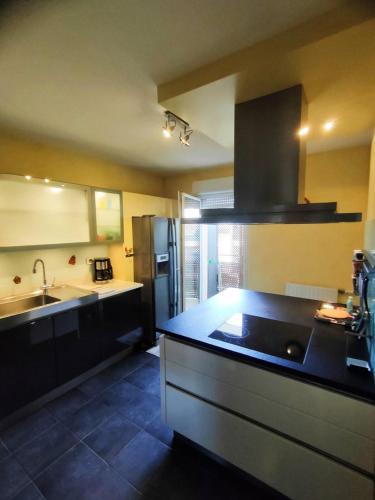 - une cuisine avec un plan de travail noir et un évier dans l'établissement PARVIS : Calme, vue, élégant, spacieux, sécurisé et central, à Agde