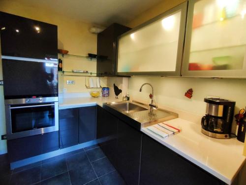 une cuisine avec un évier et un micro-ondes dans l'établissement PARVIS : Calme, vue, élégant, spacieux, sécurisé et central, à Agde
