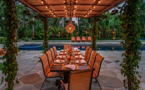 a dining table in a patio with a pool at Sea Ranch by Paradise Retreats in Montecito