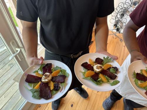a man holding two white plates of food at Fire Mountain in Highlands