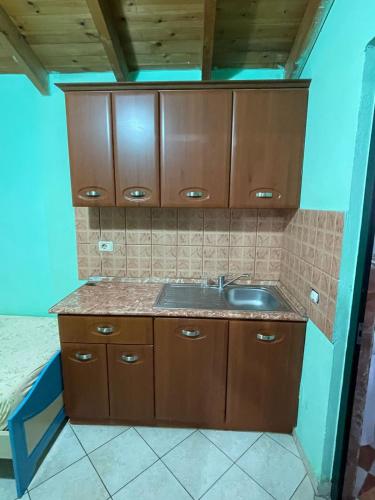 a kitchen with a sink and wooden cabinets at Sea flavor in Shëngjin