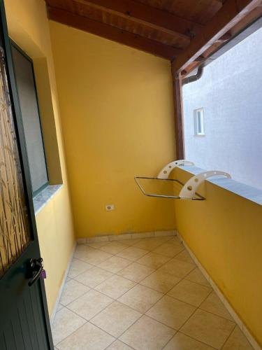a room with a yellow wall and a door at Sea flavor in Shëngjin