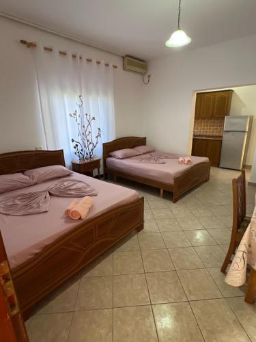 two beds sitting in a room with a kitchen at Sea flavor in Shëngjin