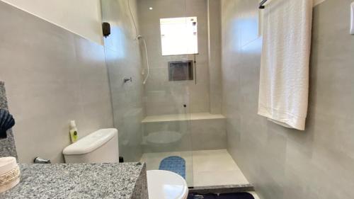 a bathroom with a glass shower and a toilet at Casa completa Porto Sauipe in Porto de Sauipe
