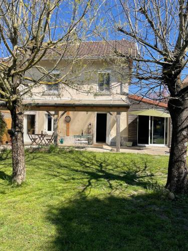 Charmante maison de campagne proche du lac de Paladru في Valencogne: منزل أمامه شجرة