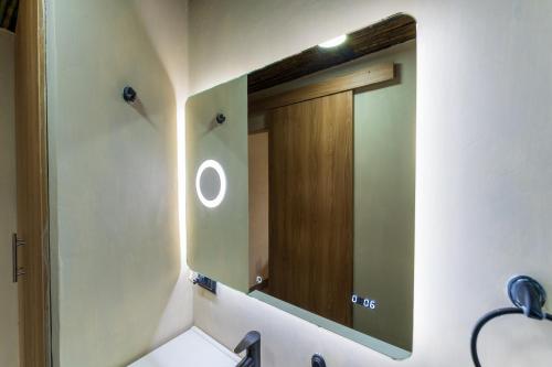 a bathroom with a mirror and a wooden door at Rincon de la Sierra Minca in Minca