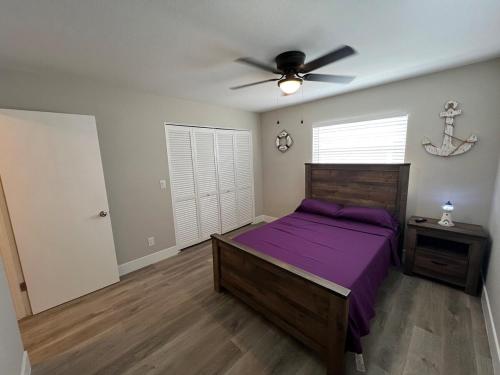 a bedroom with a purple bed and a ceiling fan at Venice Florida near beach in Venice