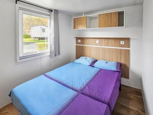 deux lits dans une petite pièce avec une fenêtre dans l'établissement laly, à Litteau