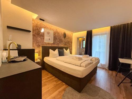 a bedroom with a large bed and a desk in it at Luna Studios Zillertal in Hippach
