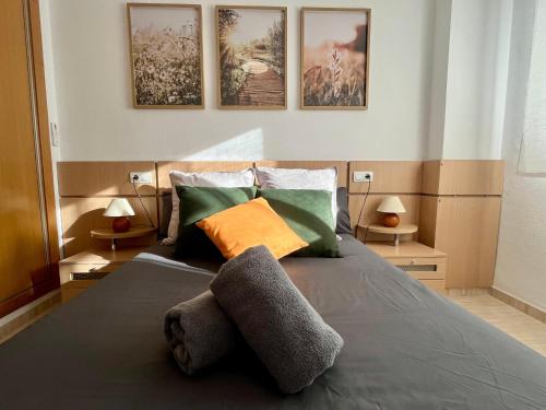 a bedroom with a bed with three pictures on the wall at Apartamento Mar Salá in Oropesa del Mar