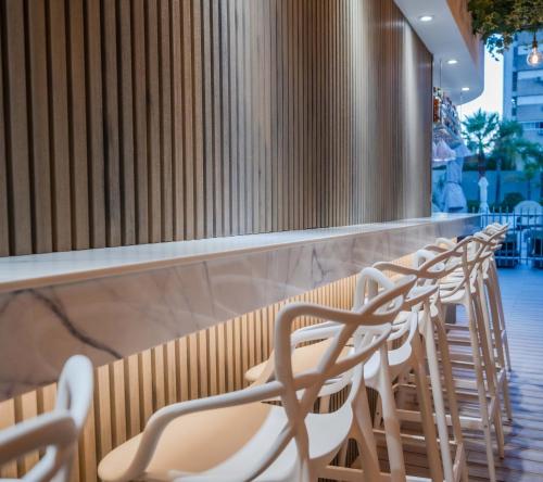 a row of chairs lined up at a bar at Holiday Inn Rosario by IHG in Rosario