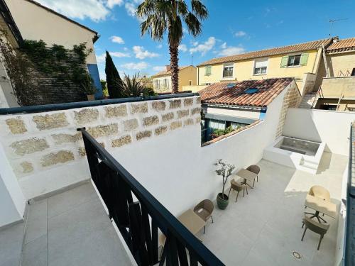 a view of a balcony with chairs and a building at 27 côté remparts in Aigues-Mortes