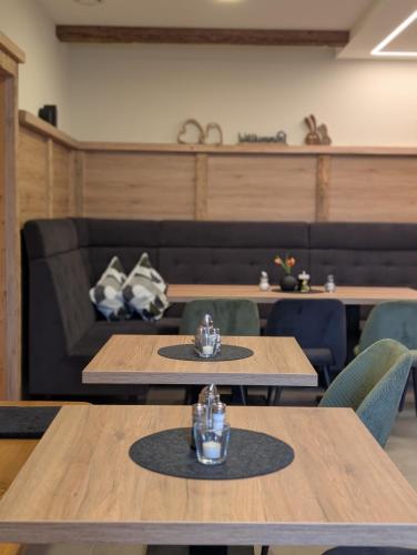 a dining room with tables and chairs and a couch at Gästehaus Arracher Hof in Arrach