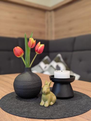 a vase and a frog sitting on a table with flowers at Gästehaus Arracher Hof in Arrach