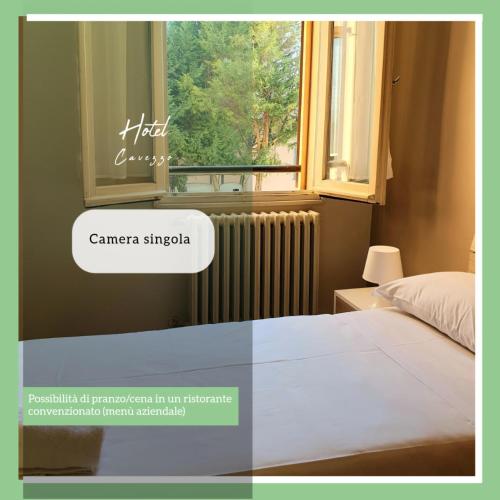 a bedroom with a bed and a radiator and a window at Hotel Cavezzo in Cavezzo