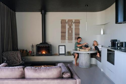 a man and a woman sitting at a table in a kitchen at Zensi Retreat - Villa in Eurunderee