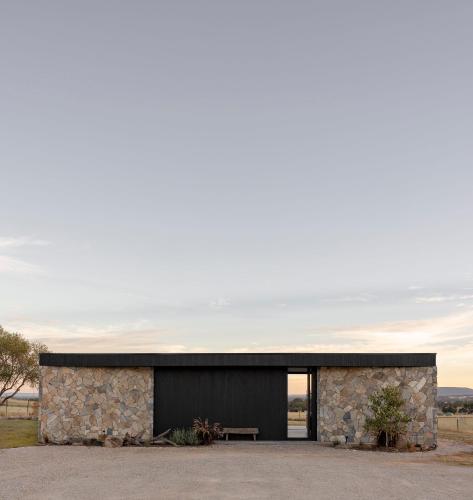 a stone house with a black facade at Zensi Retreat - Villa in Eurunderee