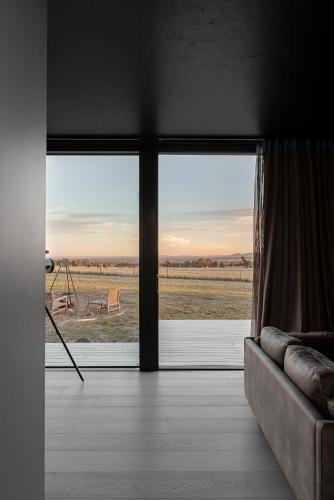 a living room with a large window and a couch at Zensi Retreat - Villa in Eurunderee