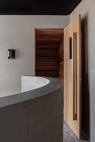 a kitchen with a concrete counter and a wooden door at Zensi Retreat - Villa in Eurunderee