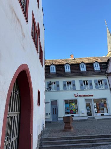 a white building with a gate in front of it at Ferienwohnung Karschter Reisehäusle in Karlstadt