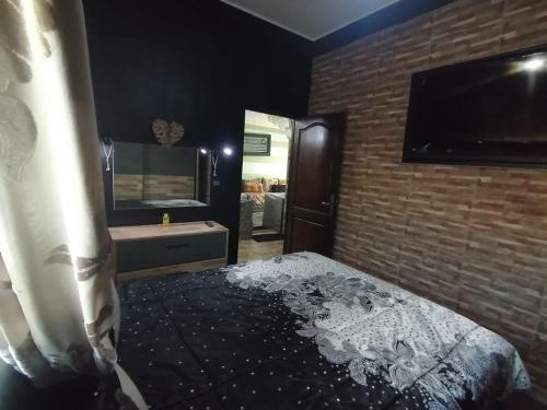 a bedroom with a bed and a bathroom with a sink at Appartement très calme a 10 mn de mehdia in Kenitra