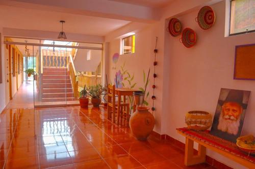 a living room with a tile floor and a staircase at Shanti Hotel Pisac in Pisac