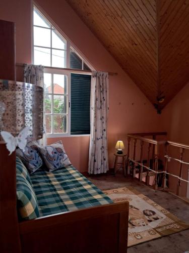 a bedroom with a bed and a large window at O Chalé das Borboletas in Santa Maria Madalena