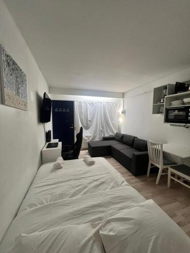 a large white bed in a room with a couch at Studio Apartment in Airport Area in Copenhagen
