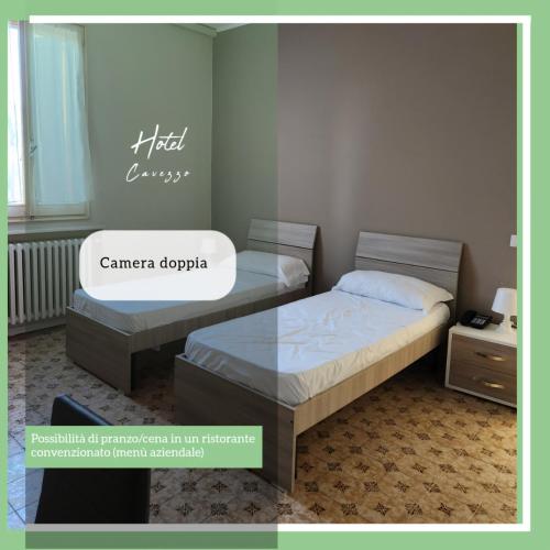 two beds in a bedroom with a sign that reads camancaoda at Hotel Cavezzo in Cavezzo