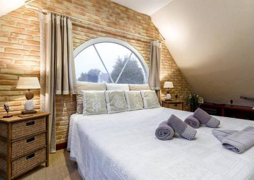 a bedroom with a large bed with a brick wall at Le Clos de Kerhouil in Sainte Anne d'Auray 
