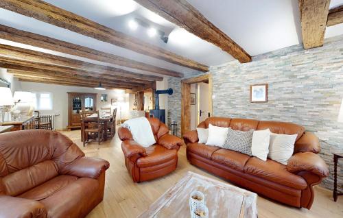 Una sala de estar con muebles de cuero y una pared de ladrillo. en Amazing Home In Bouxwiller With Wifi, en Bouxwiller