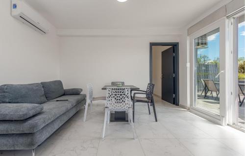 a living room with a couch and a table and chairs at Awesome Home In Povljana With Wifi in Povljana
