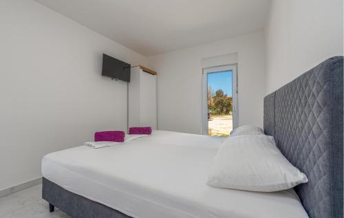 a white bedroom with a large bed and a window at Awesome Home In Povljana With Wifi in Povljana