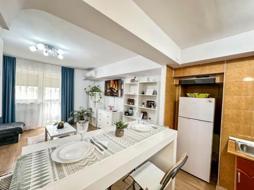 a kitchen and living room with a table and a refrigerator at Sunrise Apartments City Center in Bucharest