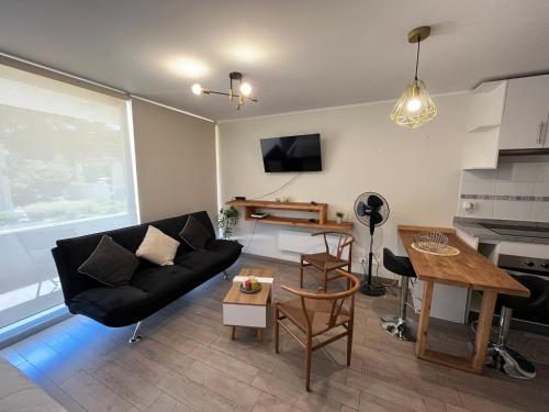 a living room with a couch and a table at Departamento de un ambiente in Curicó