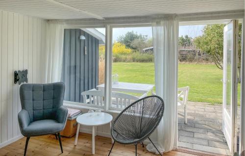 a porch with a chair and a table and a patio at 2 Bedroom Lovely Home In Dannemare in Dannemare