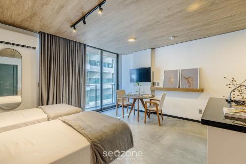 a bedroom with a bed and a table with a desk at NWTs - Estúdios em Prédio com Vista Mar in Maceió
