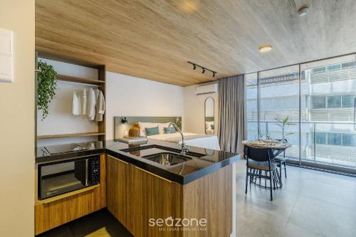 a kitchen with a sink and a table in a room at NWTs - Estúdios em Prédio com Vista Mar in Maceió
